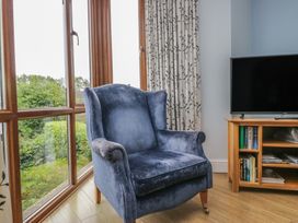 A living room with an armchair and television at Langtree in Arnside