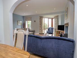 A living room with a sofa, armchair, and television at Langtree in Arnside