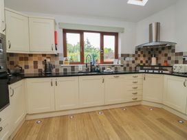 A kitchen with cabinets and a window at Langtree in Arnside