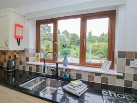 A kitchen with a sink and window overlooking the garden at Langtree in Arnside