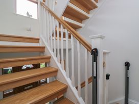 A staircase with wooden steps and banister at Langtree in Arnside