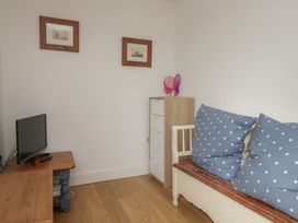 A living room with a television and sofa with cushions at Langtree in Arnside