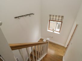 A staircase with a window and light fixture at Langtree in Arnside