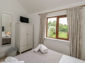 A bedroom with a bed and wardrobe at Langtree in Arnside