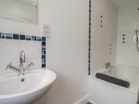 A bathroom featuring a washbasin and bathtub at Langtree in Arnside