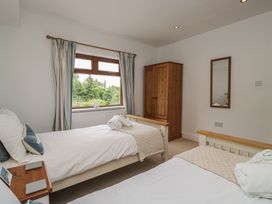 A bedroom with two beds and a wardrobe at Langtree in Arnside