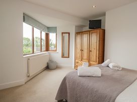 A bedroom with a bed and wardrobe at Langtree in Arnside