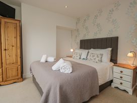 A bedroom with a bed and wardrobe at Langtree in Arnside