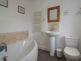 A bathroom with a bathtub, sink, and toilet at Langtree in Arnside