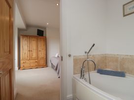 A bathroom with a bathtub and a wardrobe at Langtree in Arnside