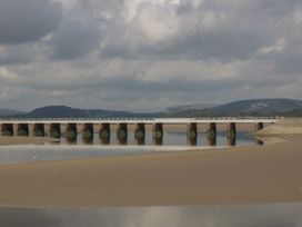 A bridge over water with sandy shore at Langtree in Arnside
