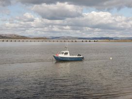 A boat on water with a pier in the background at Langtree in Arnside