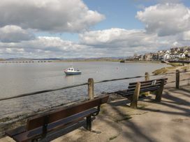 A view of a river with a boat and benches at Langtree Arnside