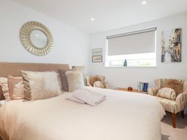 A bedroom with a bed and armchairs at Apartment no.21 in Newquay
