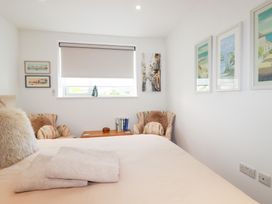 A bedroom with a bed and chairs at Apartment no.21 in Newquay