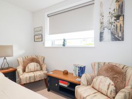 A living room with chairs and books in Apartment no.21 Newquay
