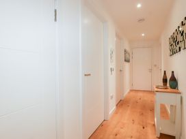 A hallway with doors and a table with vases at Apartment no.21 in Newquay