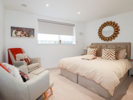 A bedroom with a bed and armchairs at Apartment no.21 Newquay