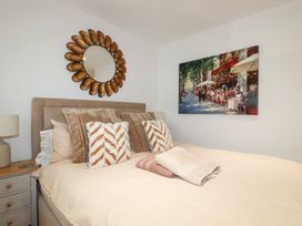 A bedroom with a bed and artwork on the wall at Apartment no.21 Newquay