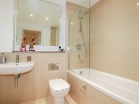 A bathroom with a bathtub, shower, toilet, and sink at Apartment no.21 Newquay