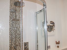 A shower with glass door and decorative crab art at 4 Ocean Reach in Bolberry