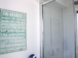 A bathroom with a shower and a decorative sign at 4 Ocean Reach in Bolberry