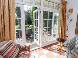 An interior seating area with armchairs near glass doors leading to an outdoor patio with a table and chairs at The Coach House in Lowick near Holy Island