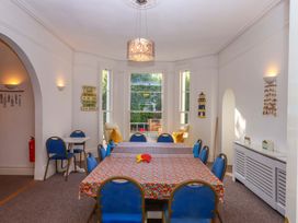 A dining room with a table and blue chairs at Babbacombe Hall in Babbacombe