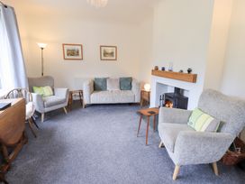 A living room with a sofa, armchairs, and a fireplace at Rock Cottage in Keswick
