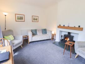 A living room with a fireplace and seating at Rock Cottage in Keswick
