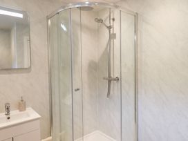A bathroom with a shower and mirror at Rock Cottage in Keswick