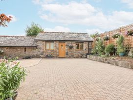 An outdoor area with a stone building and flower pots at Whitsand in Tideford