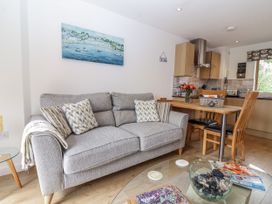 A living room with a sofa and dining table at Whitsand in Tideford