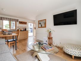 A living room with a sofa and dining table at Whitsand in Tideford
