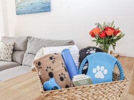 A basket with blankets and dog toys in a living room at Whitsand in Tideford