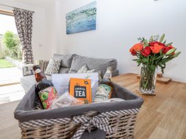 A living room with beverages and flowers at Whitsand in Tideford