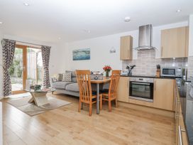 A kitchen with a dining table and sofa at Whitsand in Tideford