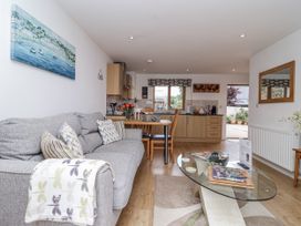 A living room with a sofa and dining area at Whitsand in Tideford