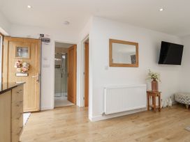 A hallway with a door and mirror at Whitsand in Tideford