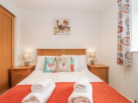 A bedroom with a bed and nightstands at Whitsand in Tideford