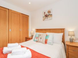 A bedroom with a bed and wooden wardrobe at Whitsand in Tideford