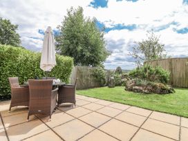 A garden with a table and chairs under an umbrella at Whitsand in Tideford