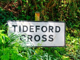 A sign that says Tideford Cross in a green setting at Whitsand in Tideford