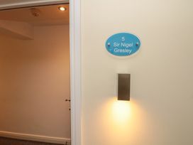 A corridor with a door and nameplate at Sir Nigel Gresley @ Engine Shed in Whitby
