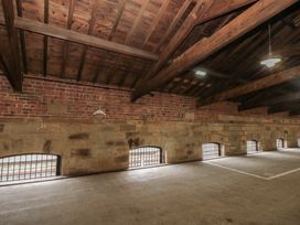 An indoor area with brick and stone walls and wooden beams at Sir Nigel Gresley @ Engine Shed in Whitby