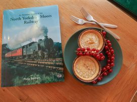 A book and a plate with two cakes and red currants at Repton @ Engine Shed Whitby