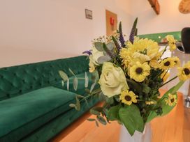 A living room with a green sofa and a vase of flowers at Repton @ Engine Shed in Whitby