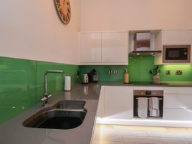 A kitchen with modern appliances and a green backsplash at Repton @ Engine Shed Whitby