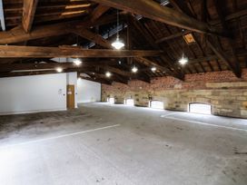 An open indoor space with wooden beams and stone walls at Repton @ Engine Shed in Whitby