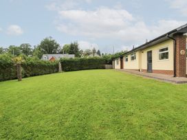 A garden with grass and a house at New Peny in Llandrindod Wells